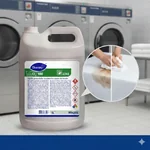 Lupa mostrando la eliminación de manchas de grasa y aceite en mantelería con Clax 100.