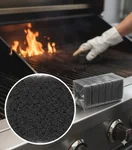 Operario utilizando la fibra negra JB para remover grasa pesada en una parrilla de restaurante.