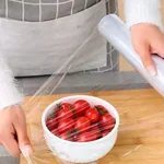 Aplicación de papel film Ecochep 38cm protegiendo bandejas de chocolate o alimentos frescos.